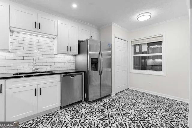 a kitchen with stainless steel appliances granite countertop a sink a refrigerator and cabinets