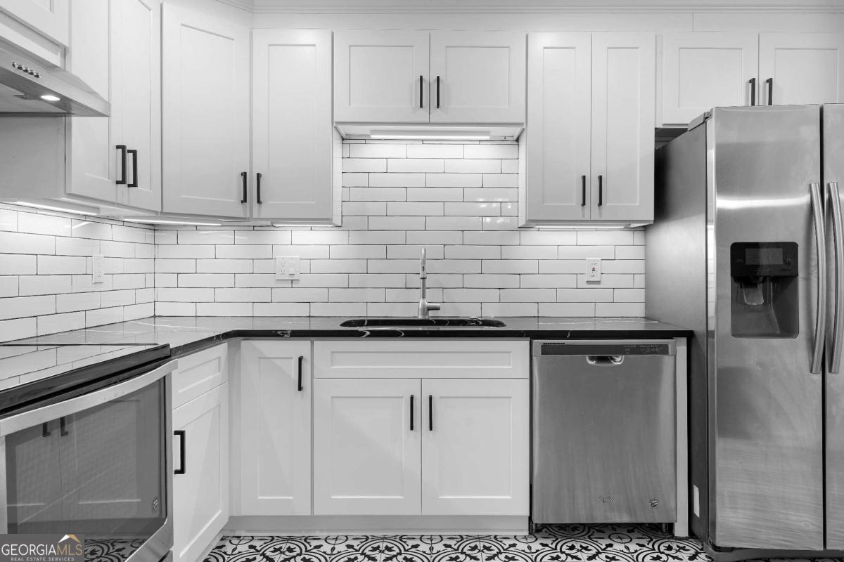 365 Winding River Drive Atlanta, GA 30350 - Photo 16 of 34 a kitchen with stainless steel appliances granite countertop a sink a refrigerator and cabinets