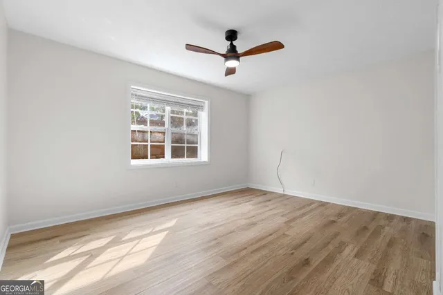 a view of empty room with wooden floor