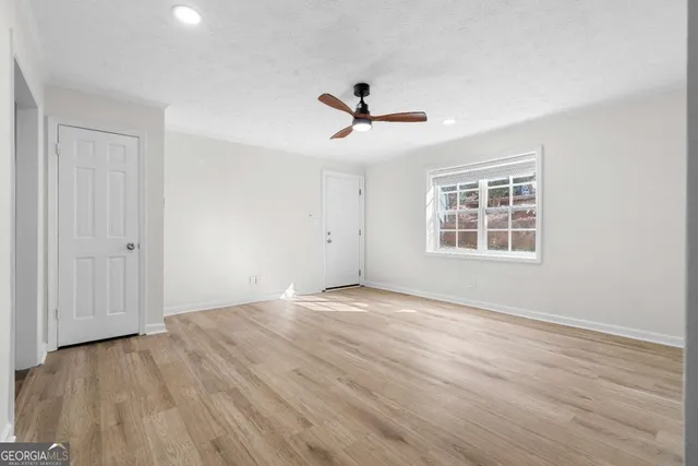 a view of empty room with wooden floor and window