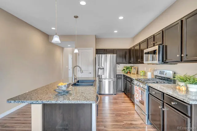 a kitchen with stainless steel appliances granite countertop a sink stove and refrigerator