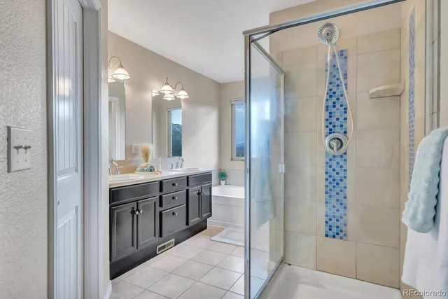 a bathroom with a double vanity sink a toilet a shower and a mirror