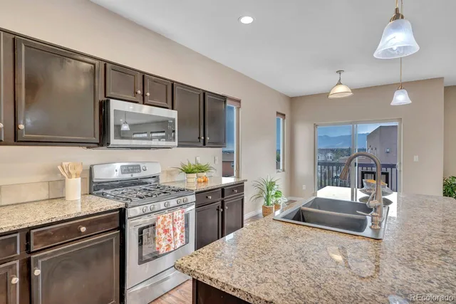 a kitchen with stainless steel appliances granite countertop a sink stove and refrigerator