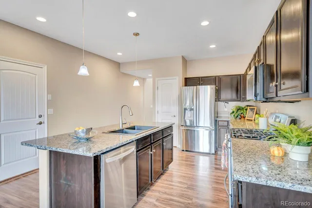 a kitchen with stainless steel appliances granite countertop a kitchen island a stove a refrigerator a oven a sink and a center island