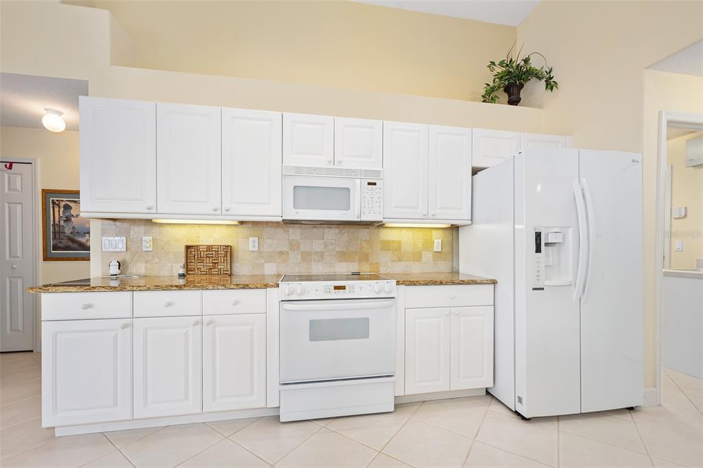 8 Gale Lane Ormond Beach, FL 32174 - Photo 17 of 77 a kitchen with white cabinets and white appliances