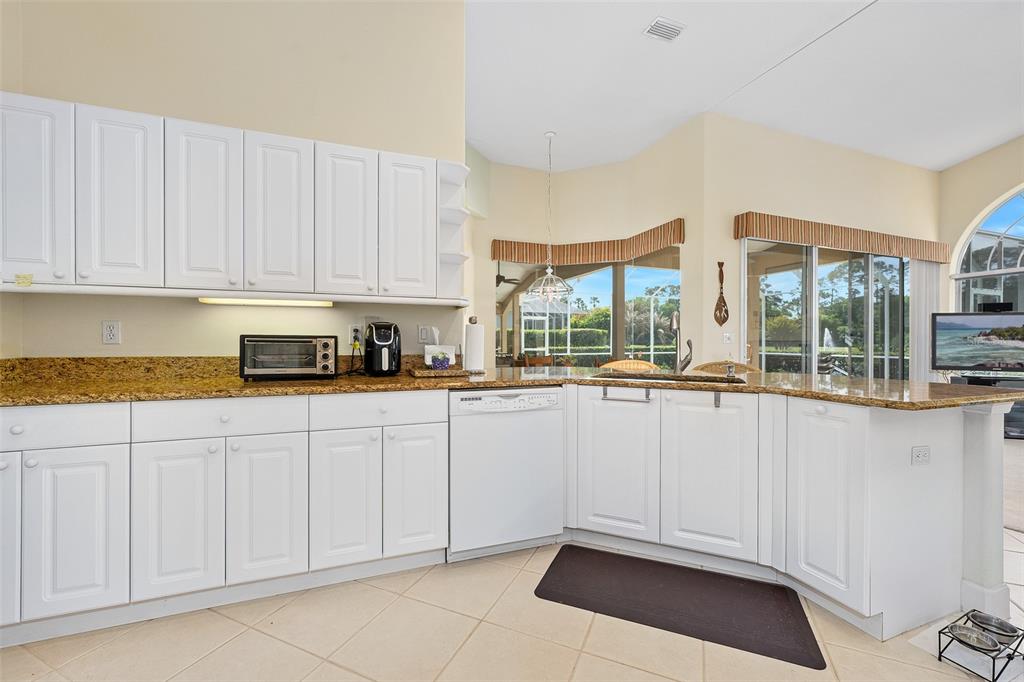 8 Gale Lane Ormond Beach, FL 32174 - Photo 18 of 77 a kitchen with granite countertop white cabinets and white appliances