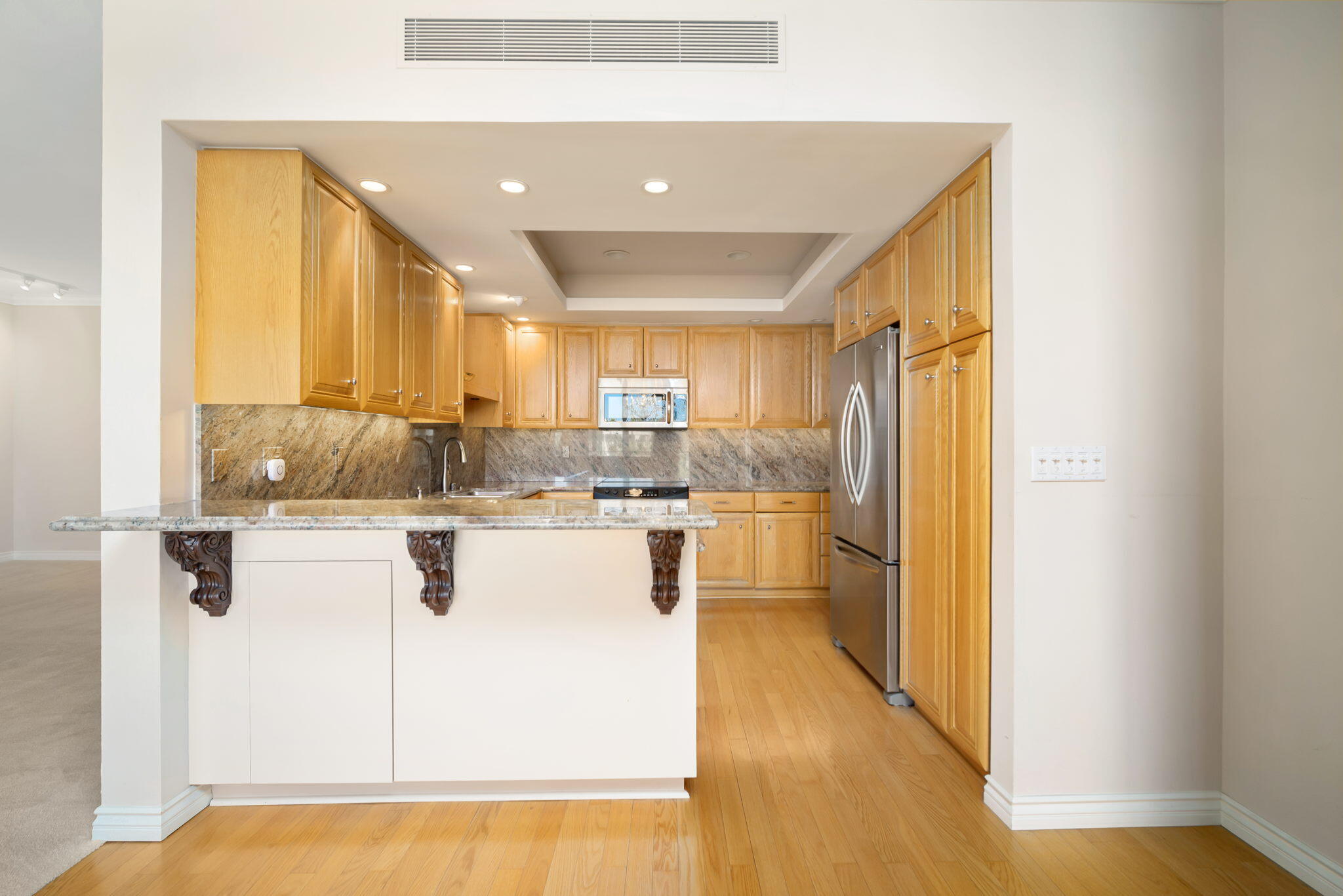 900 Island Drive, Unit 304 Rancho Mirage, CA 92270 - Photo 13 of 27 a large white kitchen with kitchen island a sink a stove and a refrigerator