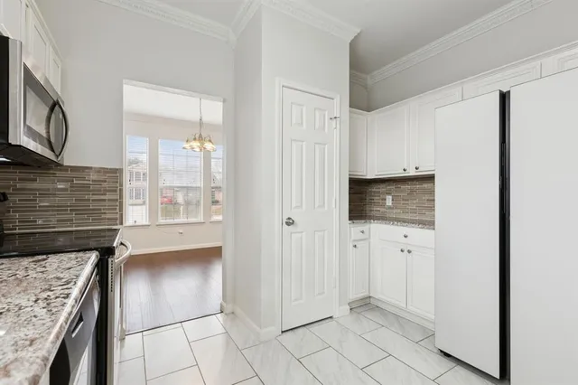 a view of kitchen with refrigerator cabinets and window