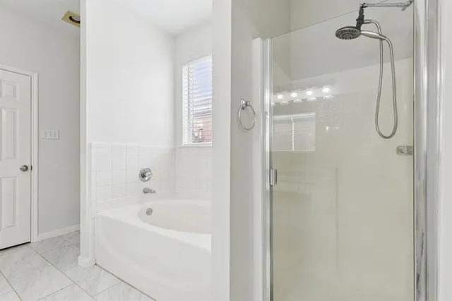 a bathroom with a bathtub and shower