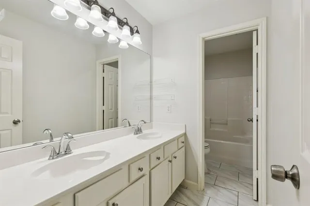 a bathroom with double vanity sink a vanity and mirror