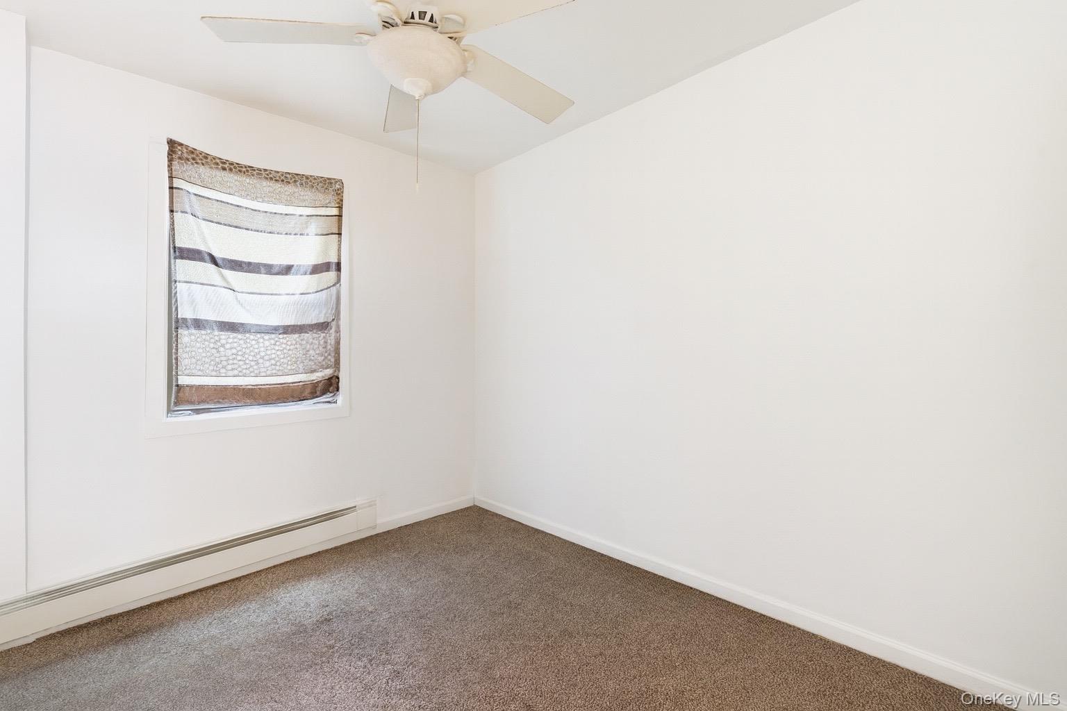 36 Ralph Avenue Brentwood, NY 11717 - Photo 14 of 23 an empty room with windows and closet