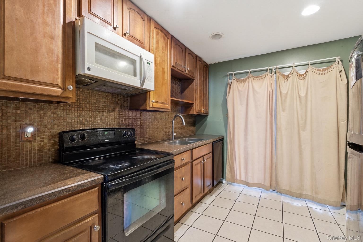 36 Ralph Avenue Brentwood, NY 11717 - Photo 7 of 23 a kitchen with stainless steel appliances granite countertop a stove and a microwave