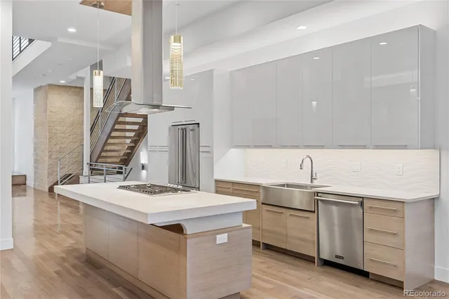 a kitchen that has a sink a stove and chairs