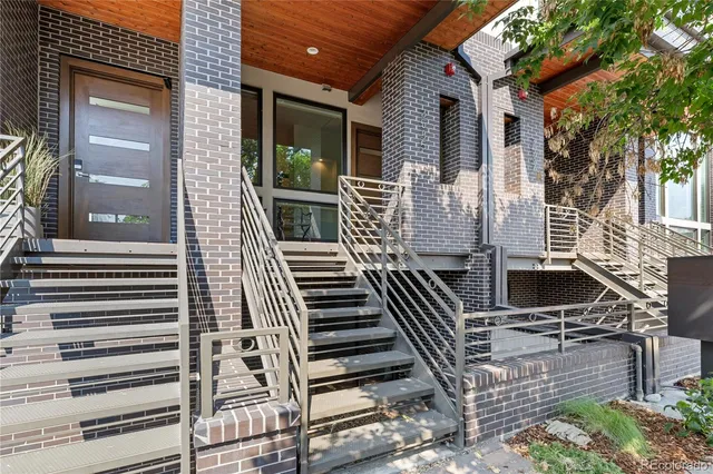 a view of a patio with two couches and deck with wooden floor and fence
