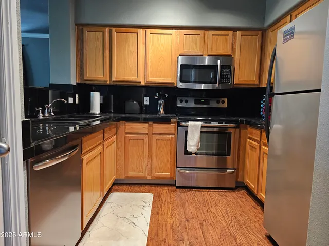 a kitchen with granite countertop a refrigerator and a stove top oven
