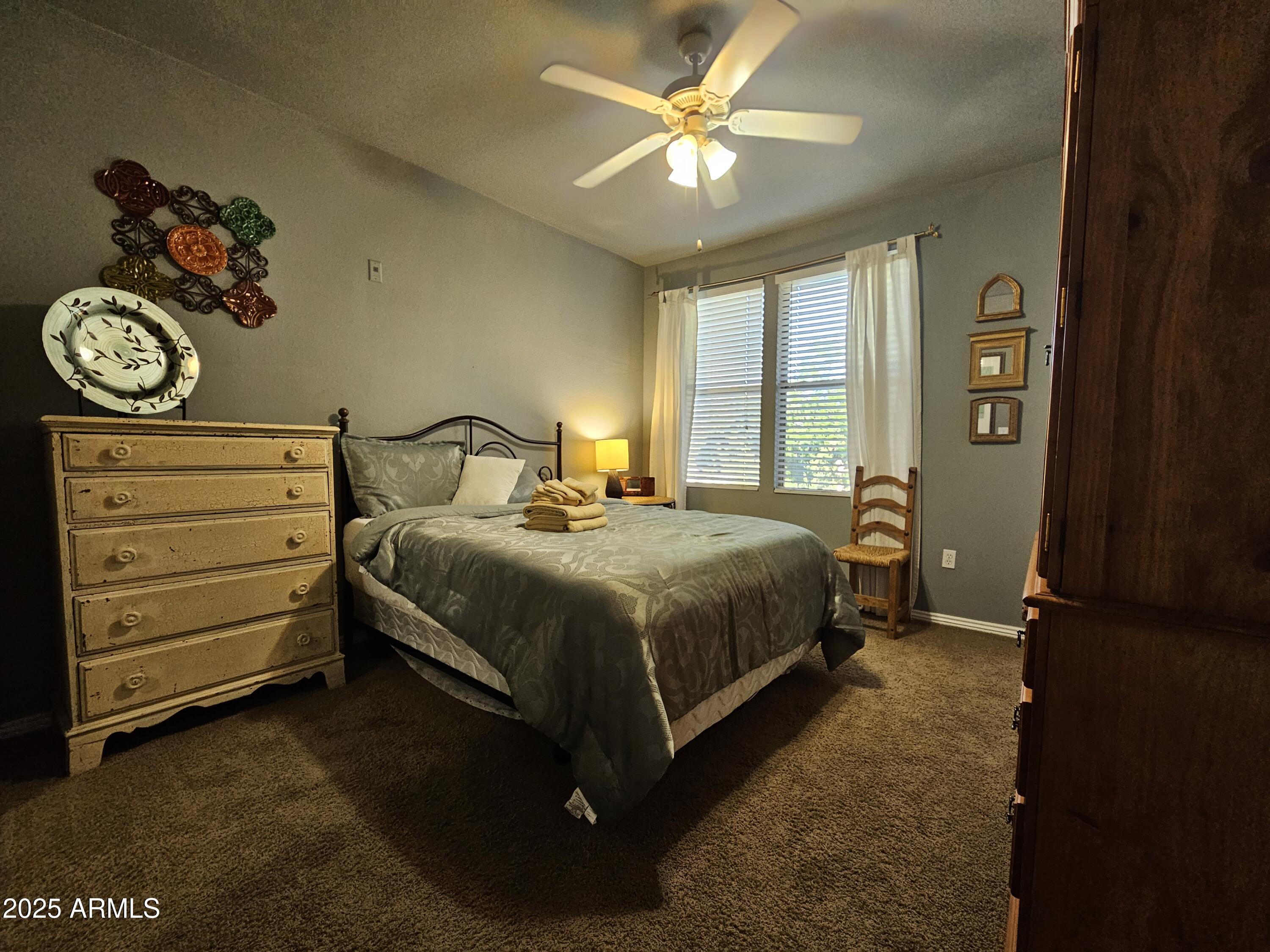 20100 North 78th Place, Unit 2180 Scottsdale, AZ 85255 - Photo 5 of 16 a bedroom with a bed and a chandelier