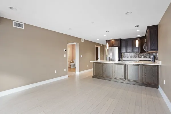 a large kitchen with kitchen island a sink stainless steel appliances and cabinets