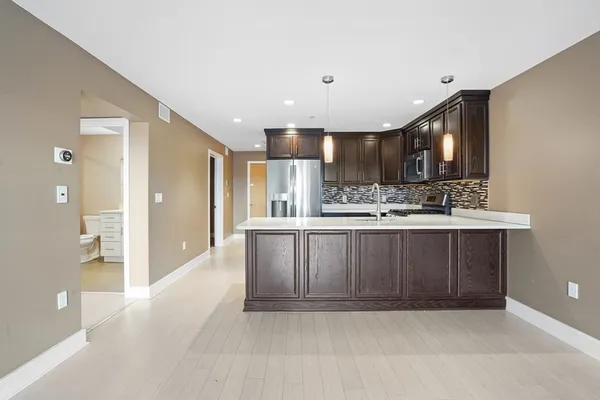 a kitchen with kitchen island granite countertop a sink and cabinets