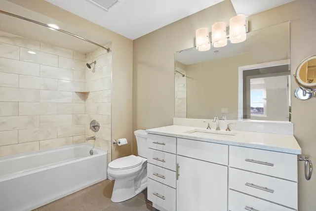 a bathroom with a toilet a sink a tub and a mirror