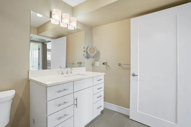 a bathroom with a sink a light fixture and a mirror