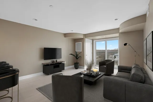 a living room with furniture a flat screen tv and a window