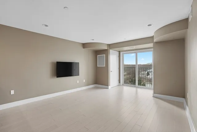a view of an empty room with a window and a flat screen tv