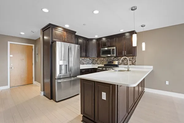 a kitchen with kitchen island a sink stainless steel appliances and cabinets