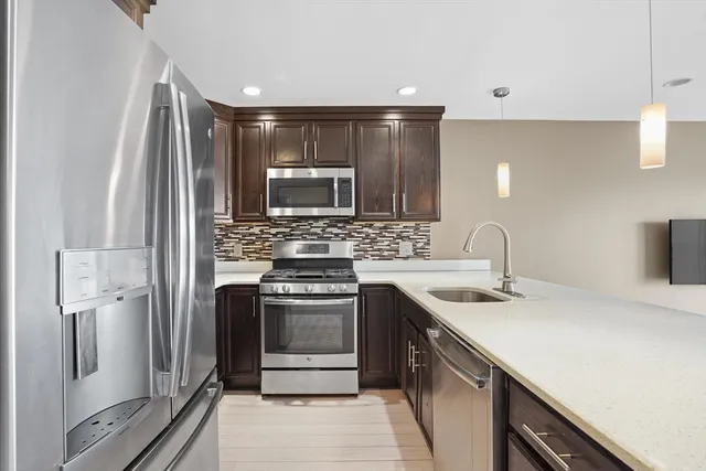 a kitchen with stainless steel appliances granite countertop a sink stove and refrigerator