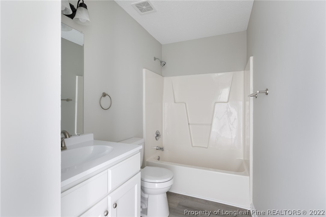 1119 Live Oak Road Coats, NC 27521 - Photo 15 of 23 a bathroom with a granite countertop sink a toilet and shower
