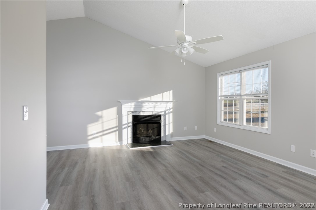 1119 Live Oak Road Coats, NC 27521 - Photo 5 of 23 an empty room with windows fireplace and wooden floor