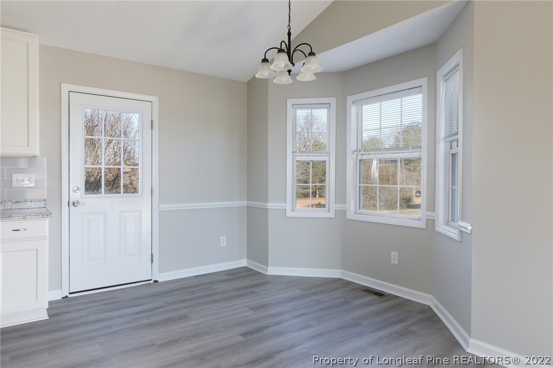 1119 Live Oak Road Coats, NC 27521 - Photo 7 of 23 an empty room with wooden floor and windows