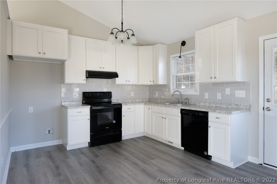 1119 Live Oak Road Coats, NC 27521 - Photo 8 of 23 a kitchen with granite countertop white cabinets and black appliances