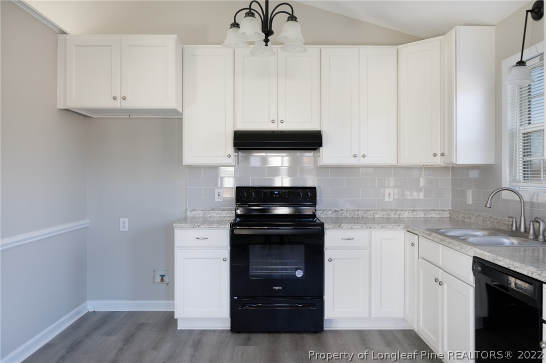 1119 Live Oak Road Coats, NC 27521 - Photo 10 of 23 a kitchen with granite countertop white cabinets and black appliances