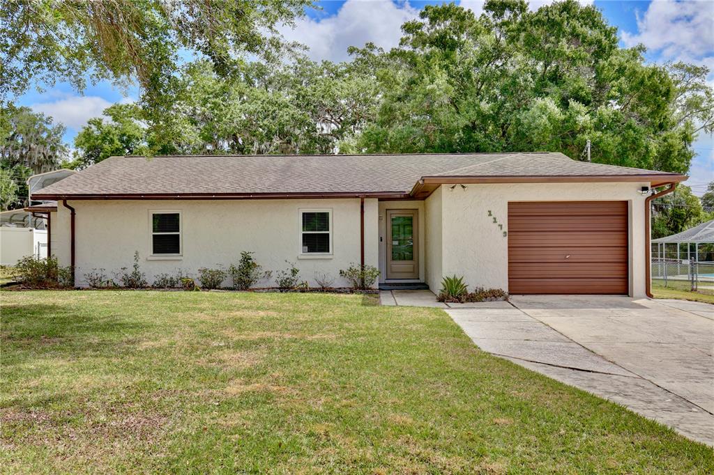 1179 Shadow Run Drive Lakeland, FL 33813 - Photo 2 of 42 a front view of a house with a garden