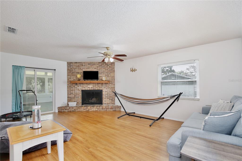 1179 Shadow Run Drive Lakeland, FL 33813 - Photo 5 of 42 a living room with furniture a fireplace and a flat screen tv