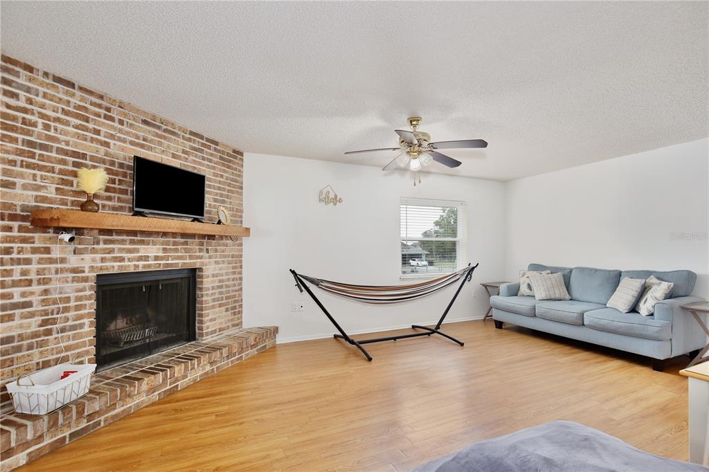 1179 Shadow Run Drive Lakeland, FL 33813 - Photo 6 of 42 a living room with furniture a fireplace and a flat screen tv