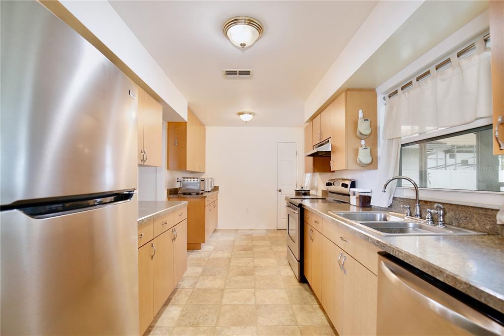 1179 Shadow Run Drive Lakeland, FL 33813 - Photo 8 of 42 a kitchen with stainless steel appliances a refrigerator sink and stove
