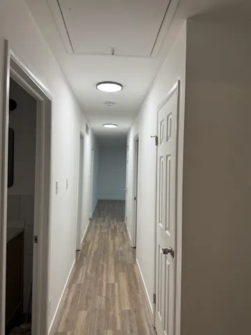 a view of a hallway with wooden floor