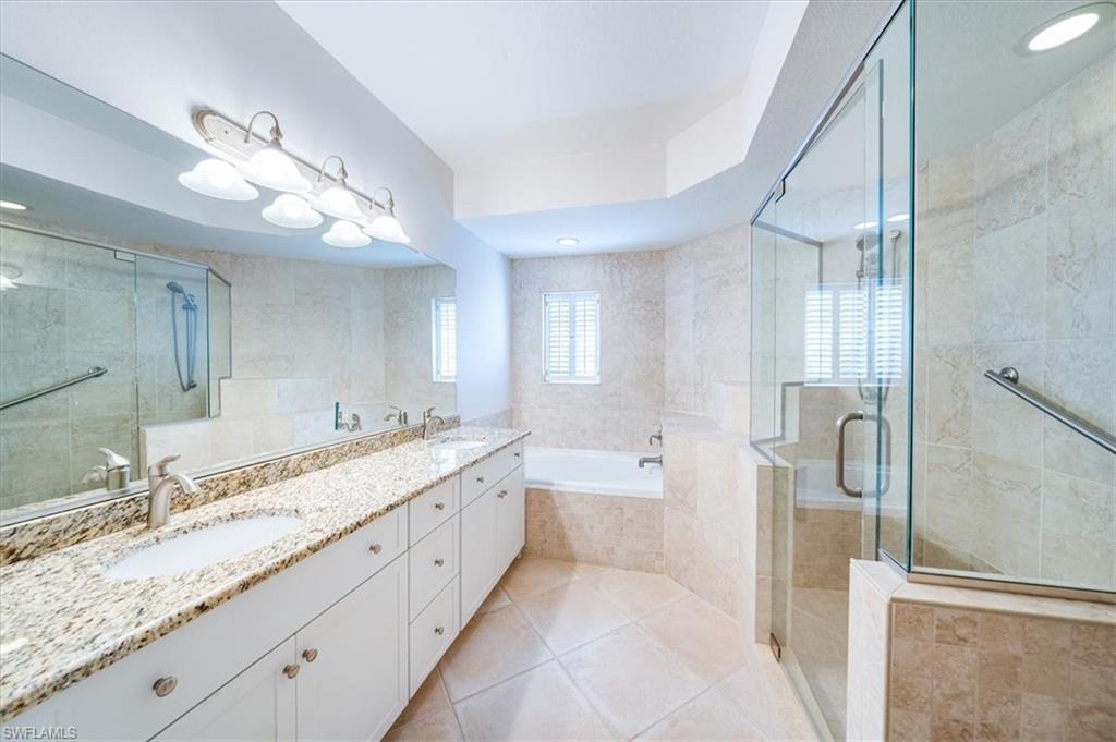 7120 Timberland Circle, Unit 101 Naples, FL 34109 - Photo 14 of 24 a large bathroom with a granite countertop sink a toilet a mirror and shower