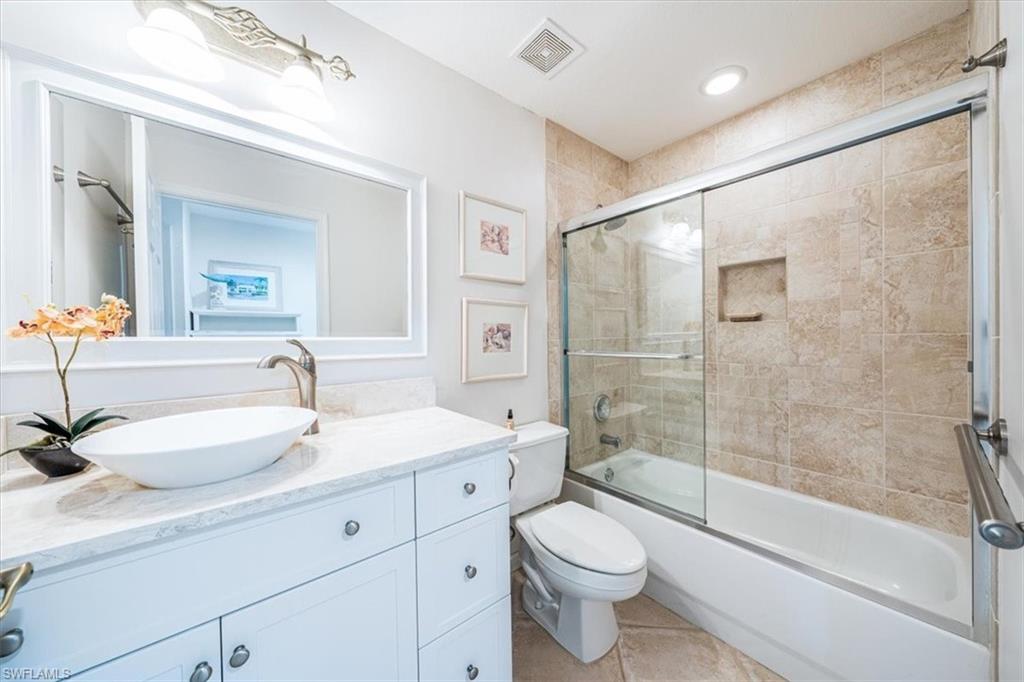 7120 Timberland Circle, Unit 101 Naples, FL 34109 - Photo 17 of 24 a bathroom with a sink a toilet and a large mirror