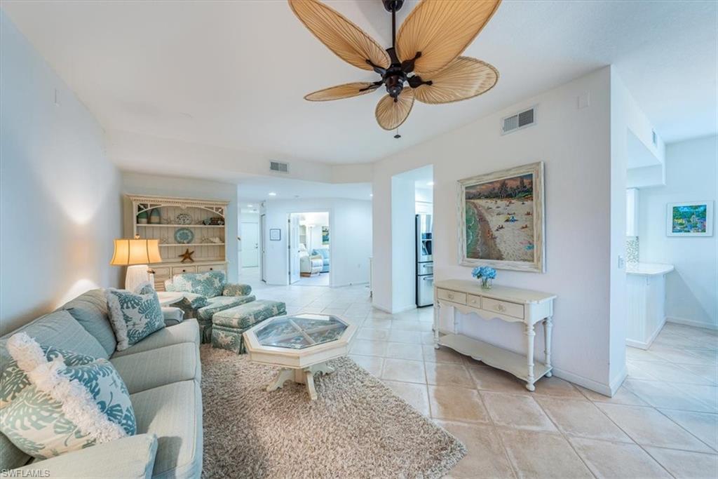 7120 Timberland Circle, Unit 101 Naples, FL 34109 - Photo 4 of 24 a living room with furniture and a wooden floor