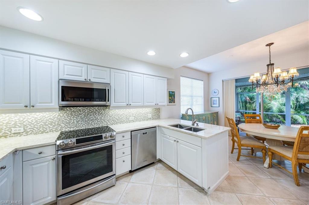 7120 Timberland Circle, Unit 101 Naples, FL 34109 - Photo 8 of 24 a kitchen with stainless steel appliances kitchen island granite countertop a sink and cabinets