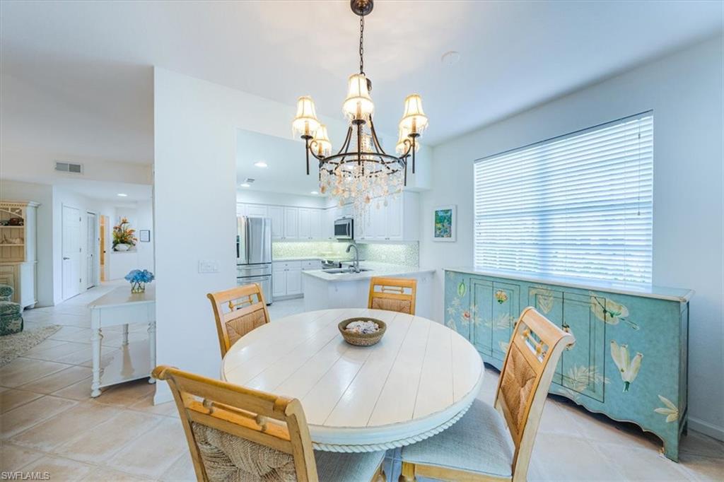 7120 Timberland Circle, Unit 101 Naples, FL 34109 - Photo 10 of 24 a dining room with furniture a window and a chandelier
