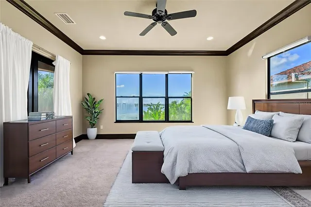 a spacious bedroom with a large bed and a chandelier