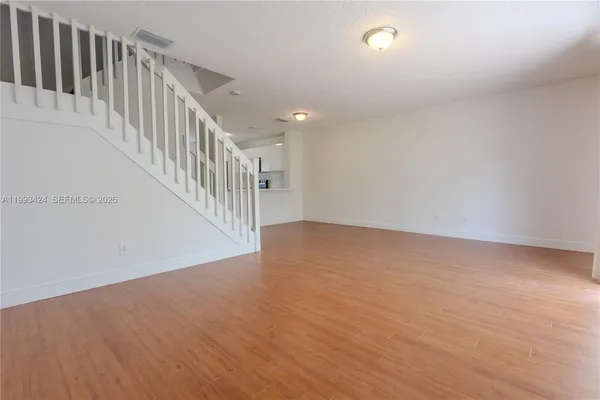 a view of a hallway with wooden floor and staircase