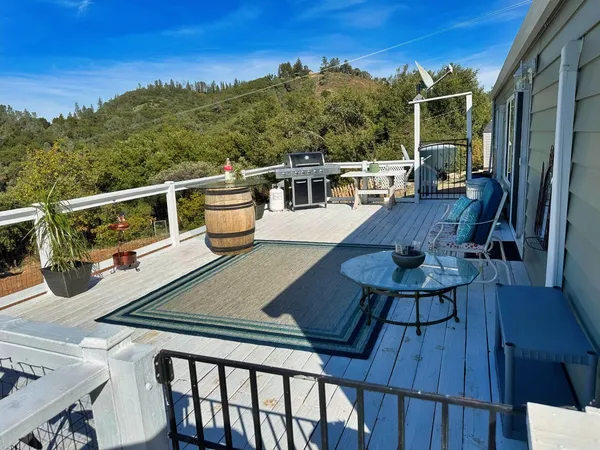a view of a balcony with chairs and wooden floor