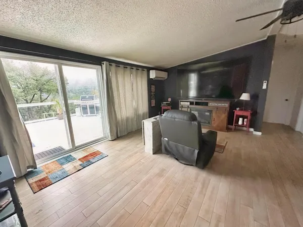 a living room with furniture a flat screen tv and a large window