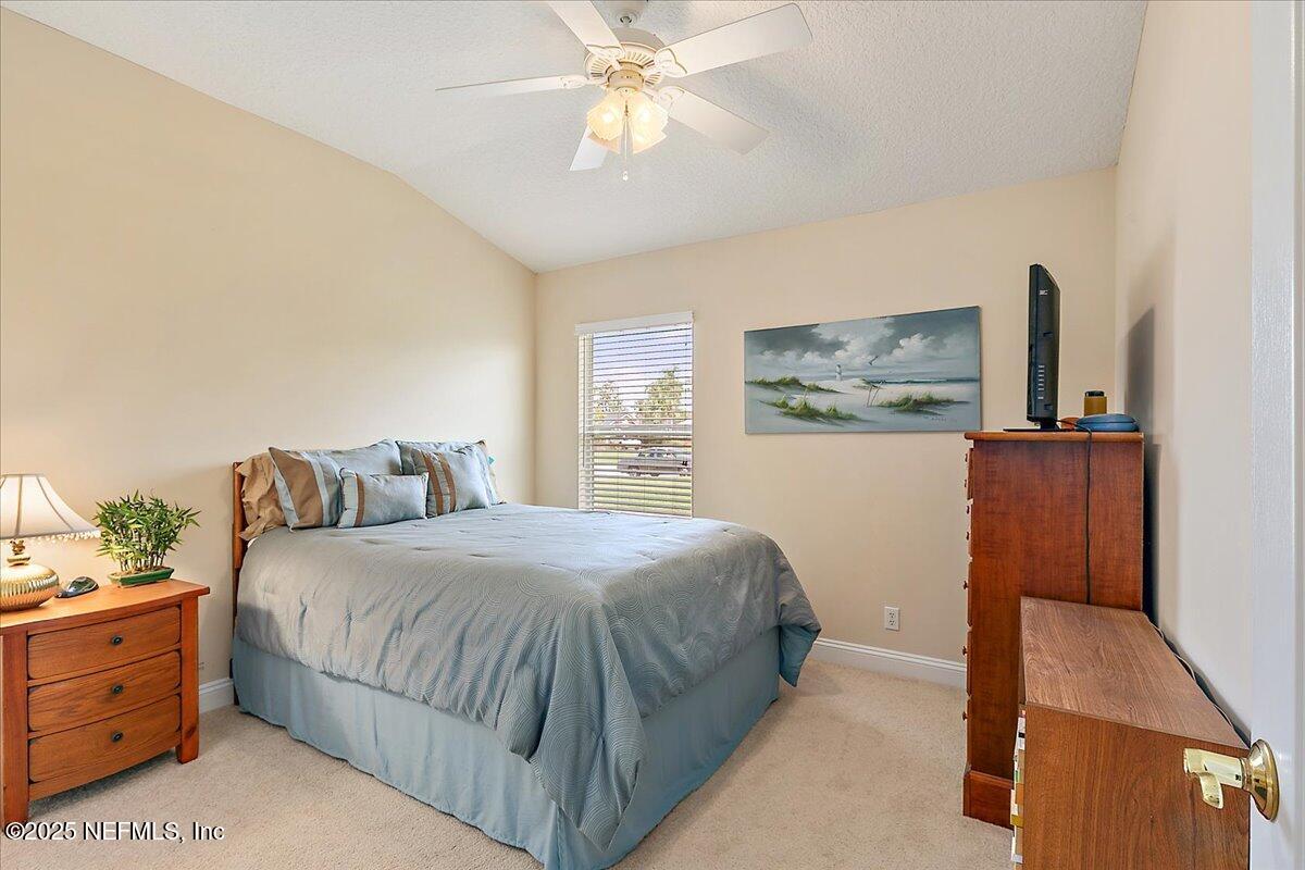 4907 Reed Island Trail Jacksonville, FL 32225 - Photo 20 of 25 a bedroom with a bed and a flat tv screen on dresser