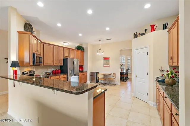 a kitchen with stainless steel appliances granite countertop a refrigerator stove top oven and sink
