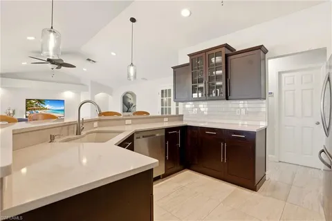 a kitchen with a sink and a stove with wooden floor